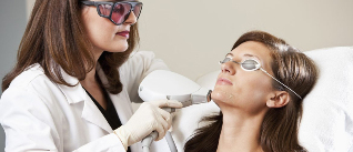 A beautician performs a procedure of laser rejuvenation
